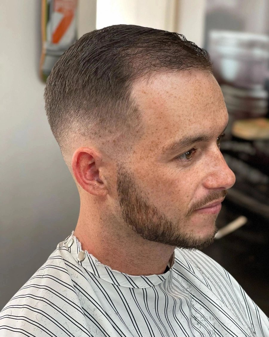 Man with a short taper fade and a trimmed stubble beard.