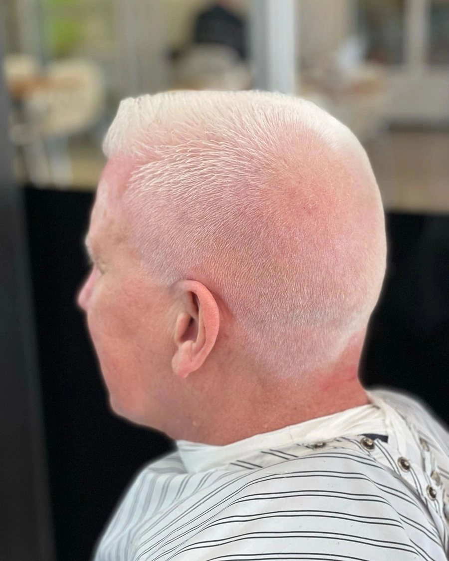 Back view of an older man with a short silver crop faded into the neckline.