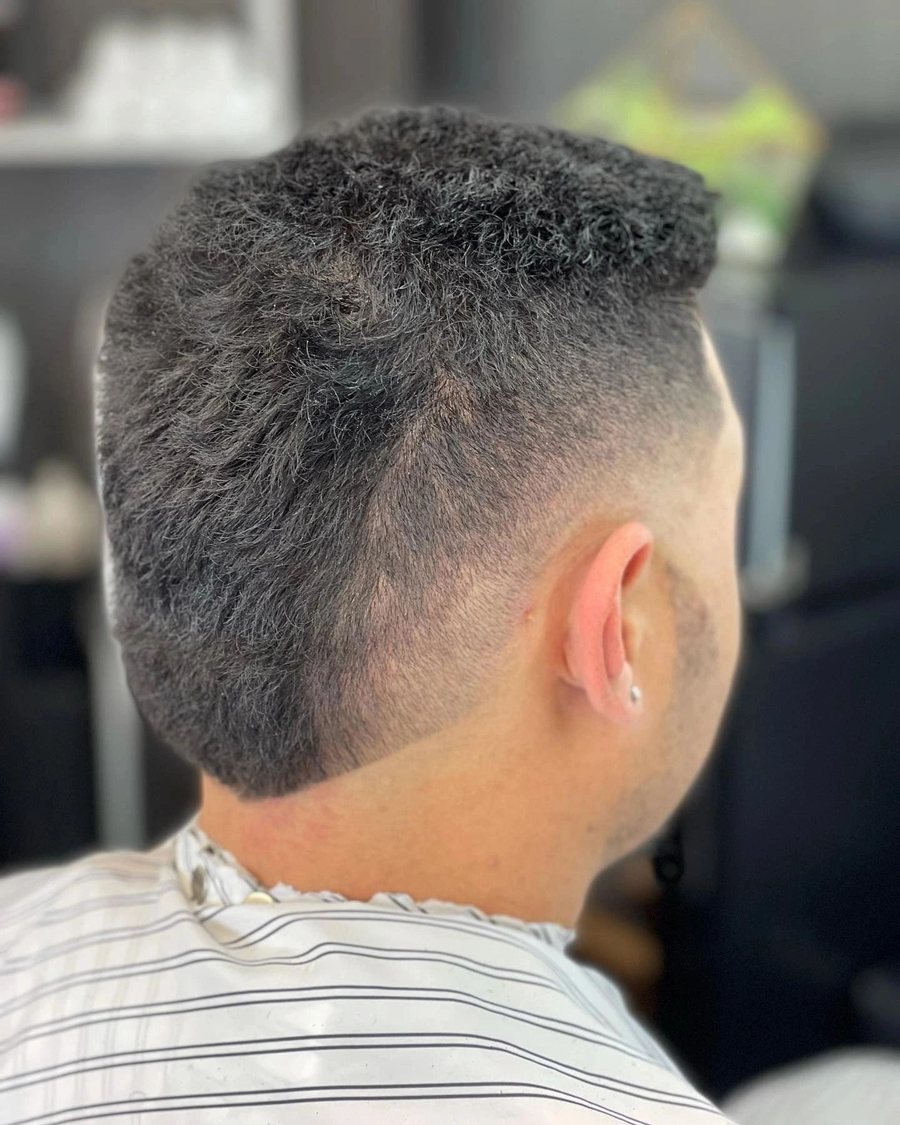 Back view of a textured dark crop blended into a skin fade.